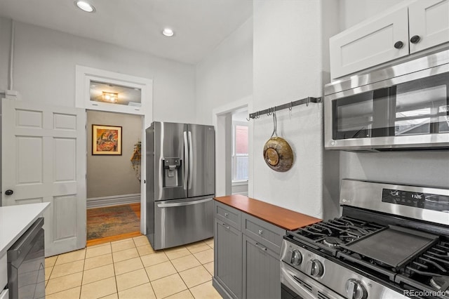 kitchen featuring white cabinetry, light tile patterned floors, gray cabinetry, and appliances with stainless steel finishes