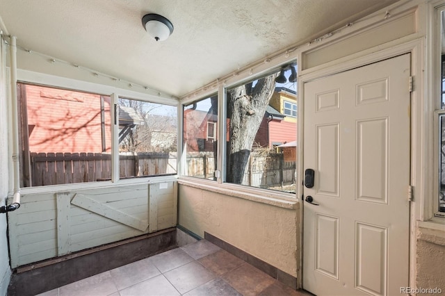 unfurnished sunroom featuring vaulted ceiling