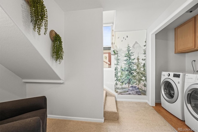 clothes washing area with cabinets and washer and dryer