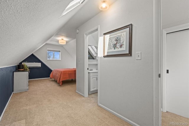 carpeted bedroom featuring lofted ceiling with skylight and a textured ceiling