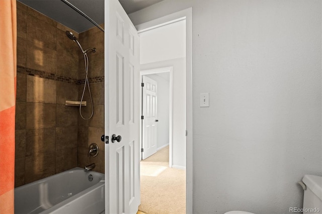 bathroom featuring tiled shower / bath and toilet