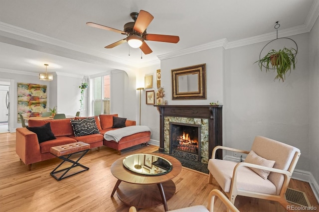 2336 N High St, Denver, CO 80205 - living room featuring light wood-style flooring, a tile fireplace, ornamental molding, and a ceiling fan
