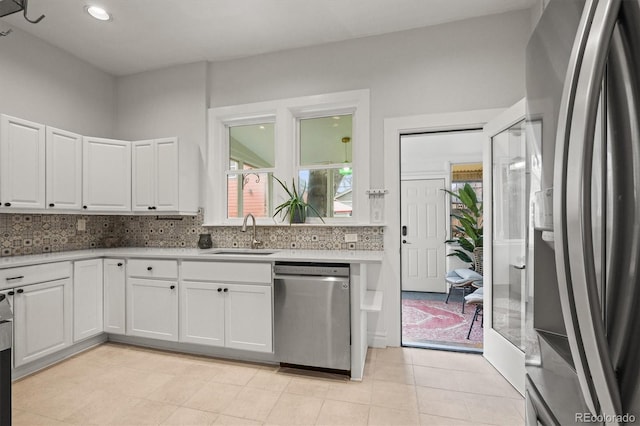 2336 N High St, Denver, CO 80205 - kitchen featuring appliances with stainless steel finishes, white cabinets, light countertops, decorative backsplash, and recessed lighting