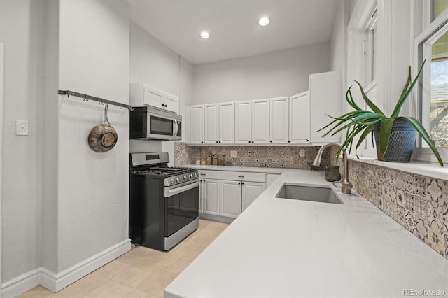 2336 N High St, Denver, CO 80205 - kitchen with stainless steel appliances, white cabinetry, tasteful backsplash, light countertops, and recessed lighting