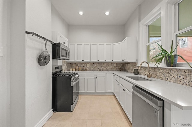 2336 N High St, Denver, CO 80205 - kitchen featuring appliances with stainless steel finishes, decorative backsplash, white cabinets, light countertops, and recessed lighting