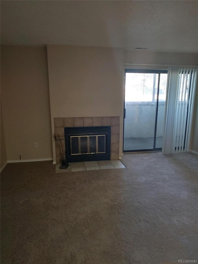 unfurnished living room featuring a fireplace, light carpet, and a textured ceiling