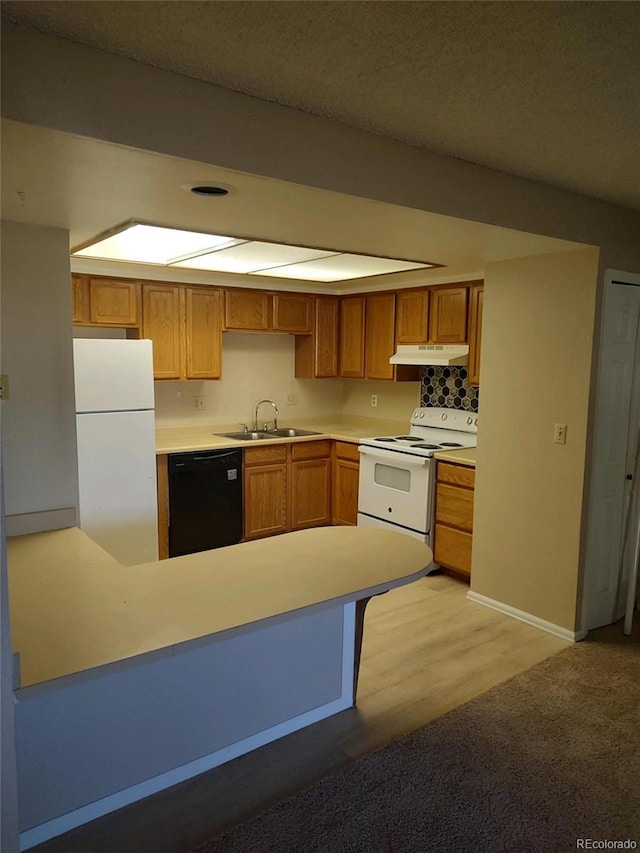 kitchen featuring white appliances, light hardwood / wood-style floors, kitchen peninsula, and sink