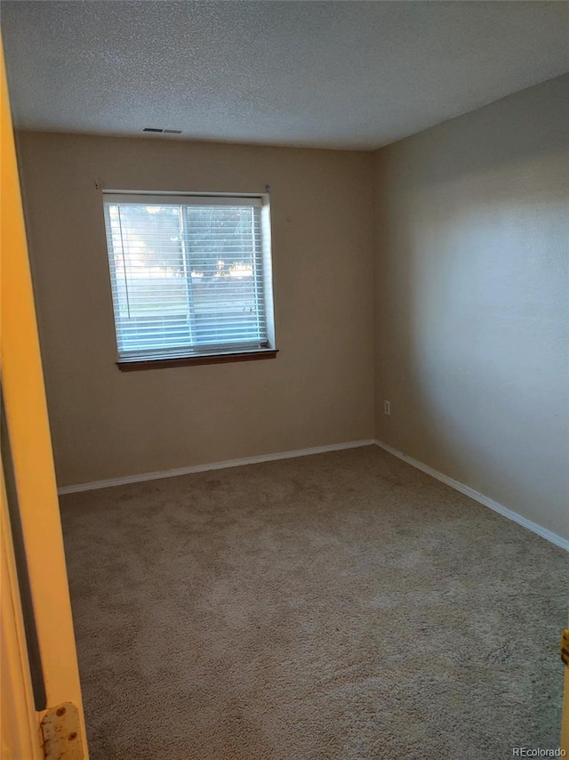 unfurnished room with a textured ceiling and carpet