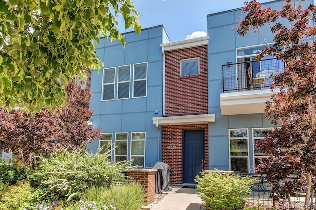 2346 Central Park Blvd, Denver, CO 80238 - view of front of home featuring stucco siding, brick siding, and a balcony