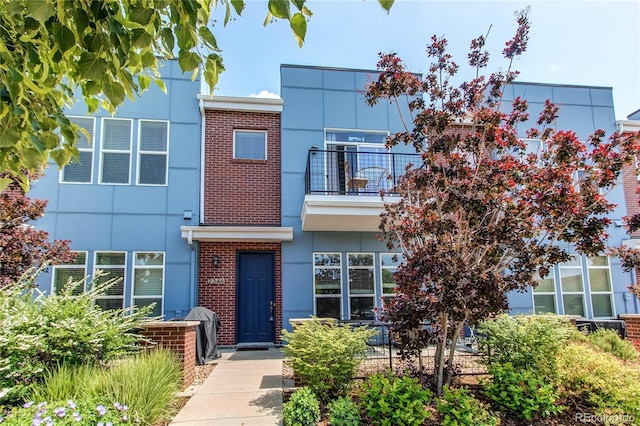 2346 Central Park Blvd, Denver, CO 80238 - view of front of home featuring a balcony, brick siding, and stucco siding