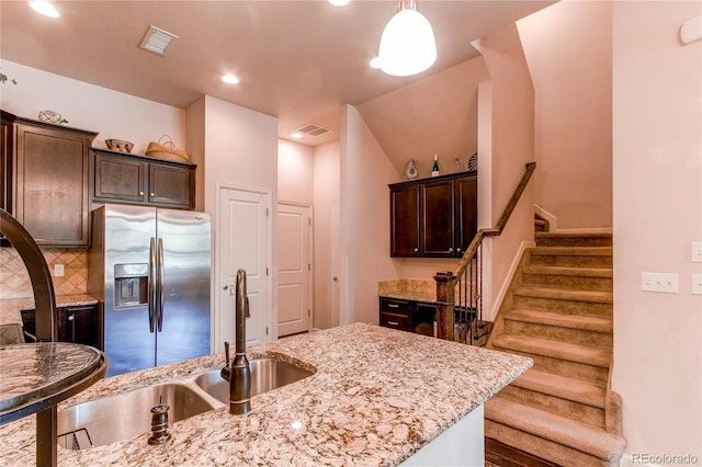 2346 Central Park Blvd, Denver, CO 80238 - kitchen with stainless steel refrigerator with ice dispenser, dark brown cabinetry, a sink, light stone countertops, and tasteful backsplash