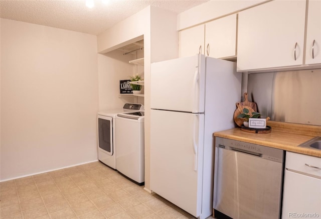 kitchen with separate washer and dryer, freestanding refrigerator, light countertops, a textured ceiling, and stainless steel dishwasher