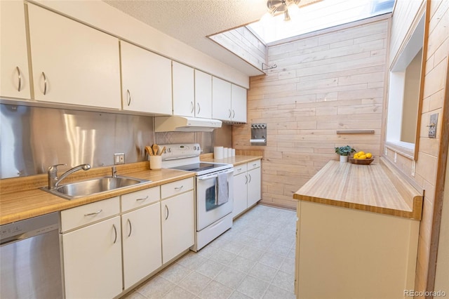 kitchen featuring under cabinet range hood, a sink, stainless steel dishwasher, white electric stove, and a skylight