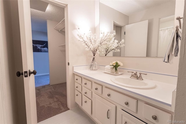 full bathroom with vanity and a textured ceiling