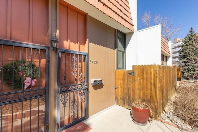 doorway to property featuring fence