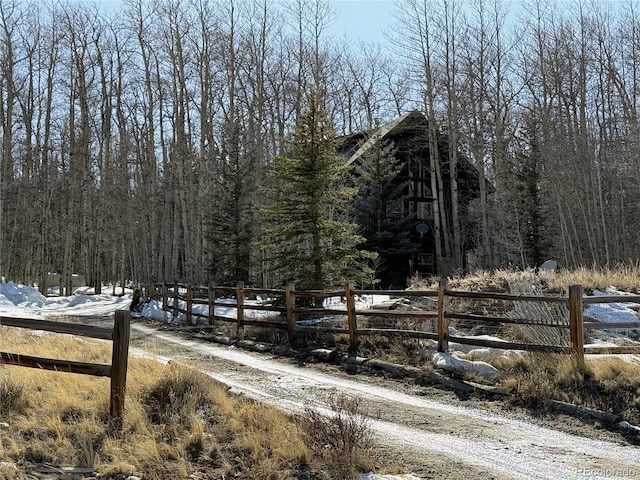 exterior space with a wooded view and fence