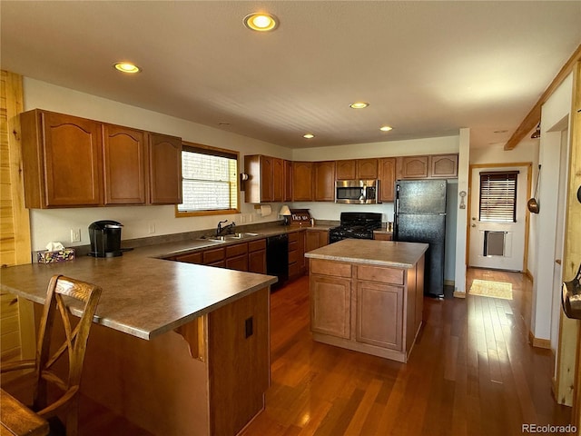 kitchen featuring brown cabinets, black appliances, and dark wood-type flooring