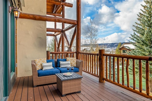 wooden terrace with an outdoor living space and a mountain view