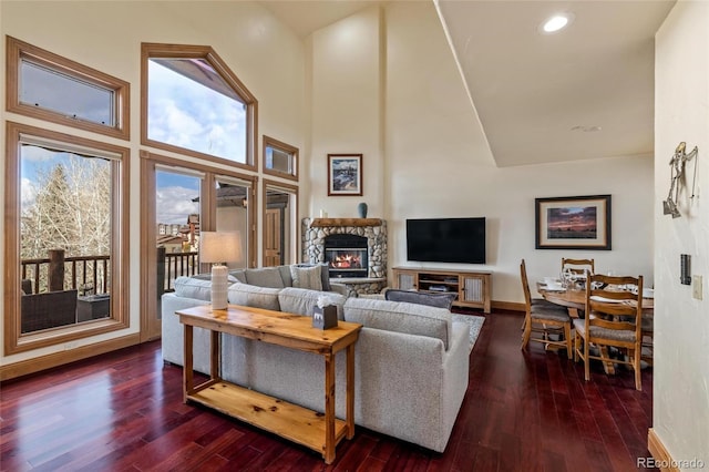 living room featuring a fireplace, a high ceiling, and dark hardwood / wood-style floors