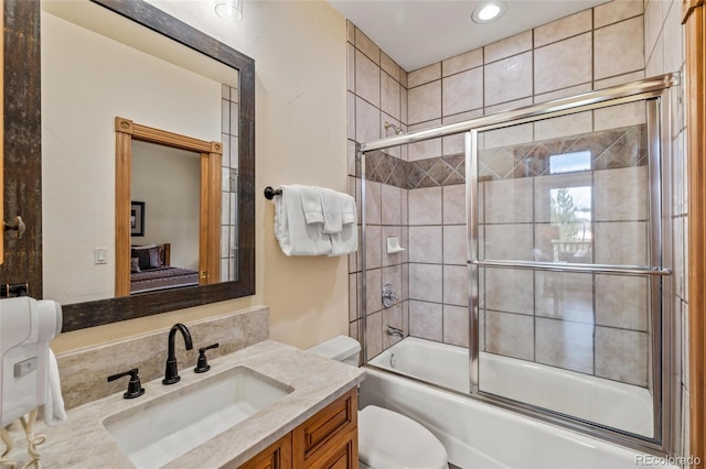 full bathroom with shower / bath combination with glass door, vanity, and toilet