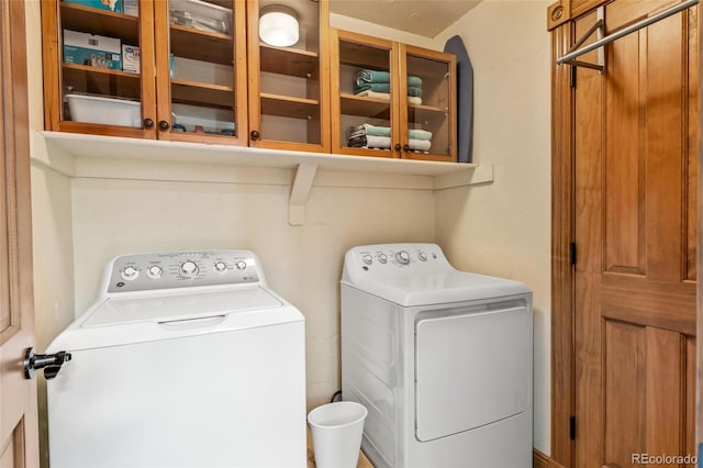 laundry room with separate washer and dryer and cabinets