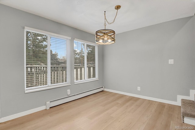 unfurnished dining area featuring a notable chandelier, wood finished floors, baseboards, and a baseboard radiator