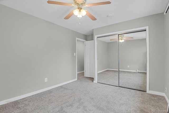 unfurnished bedroom featuring baseboard heating, baseboards, carpet floors, and ceiling fan