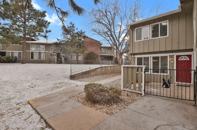 857 S Van Gordon Ct Unit H101, Lakewood, CO 80228 - view of front of property featuring board and batten siding, a fenced front yard, and a gate