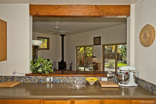 kitchen with a wood stove, ceiling fan, and tasteful backsplash