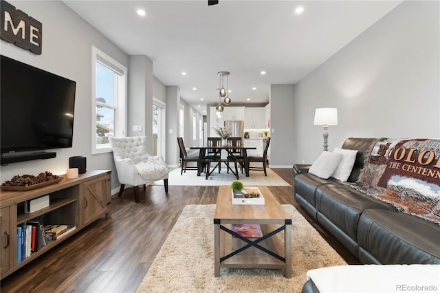 living room featuring dark wood-type flooring, recessed lighting, and baseboards