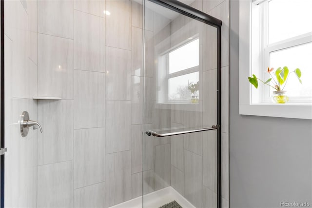 bathroom with tiled shower and a wealth of natural light