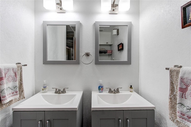 full bathroom featuring a sink and two vanities