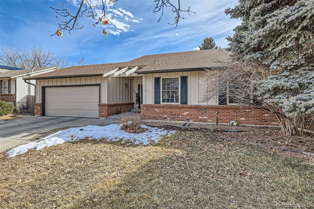 ranch-style home featuring brick siding, roof with shingles, an attached garage, board and batten siding, and driveway