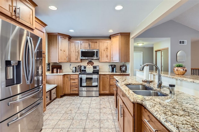 kitchen with recessed lighting, visible vents, appliances with stainless steel finishes, a sink, and light stone countertops