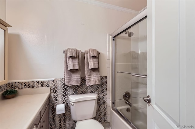 full bathroom featuring crown molding, tile walls, toilet, enclosed tub / shower combo, and vanity