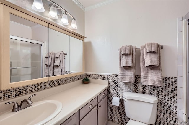 bathroom with a stall shower, toilet, crown molding, vanity, and tile walls