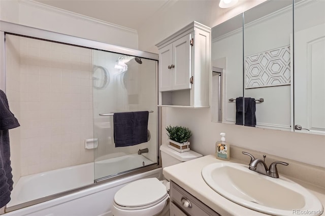 bathroom featuring toilet, bath / shower combo with glass door, crown molding, and vanity