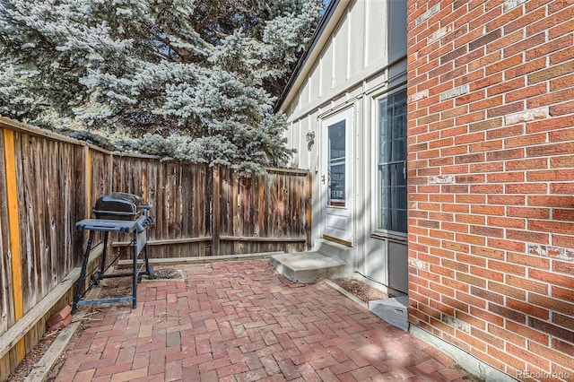 view of patio / terrace with entry steps, a grill, and fence