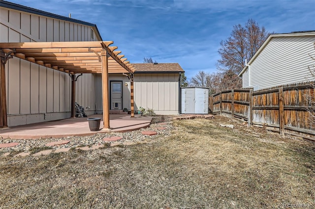 view of yard with an outbuilding, a patio, fence, a pergola, and a storage unit