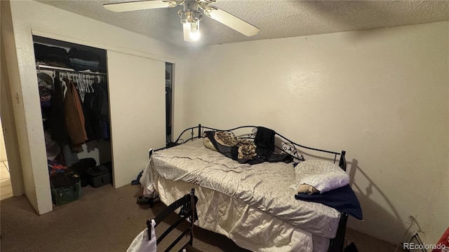 carpeted bedroom featuring ceiling fan, a textured ceiling, and a closet