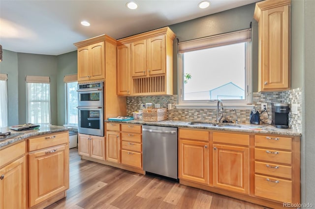 29852 E 163rd Pl, Brighton, CO 80603 - kitchen featuring stainless steel appliances, light brown cabinets, backsplash, light wood-style floors, and recessed lighting