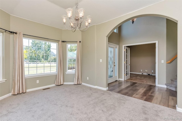 29852 E 163rd Pl, Brighton, CO 80603 - carpeted empty room featuring arched walkways, stairway, and a chandelier