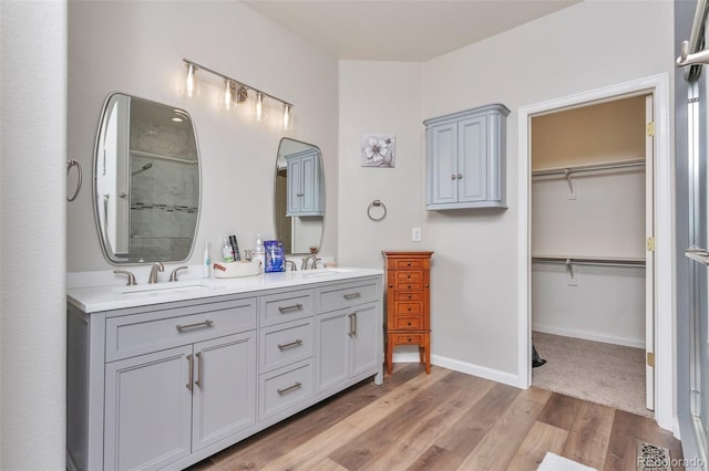 29852 E 163rd Pl, Brighton, CO 80603 - full bathroom featuring double vanity, tiled shower, wood finished floors, and a walk in closet