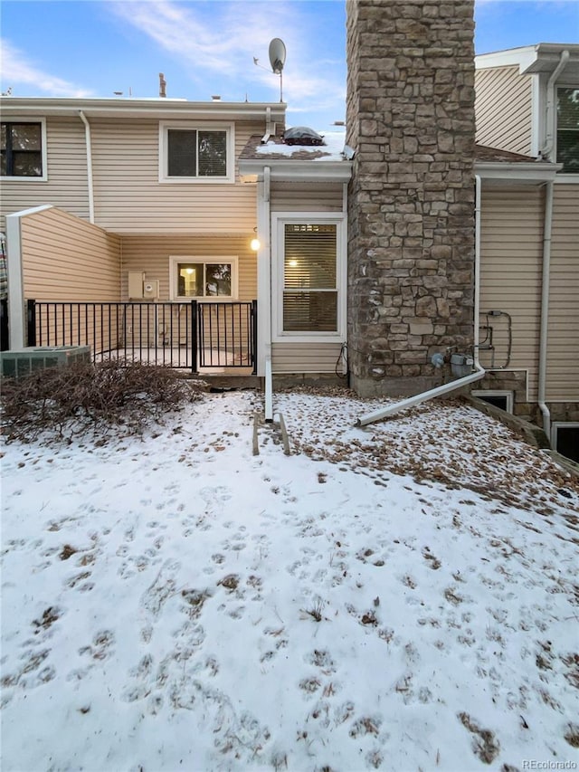 view of snow covered back of property