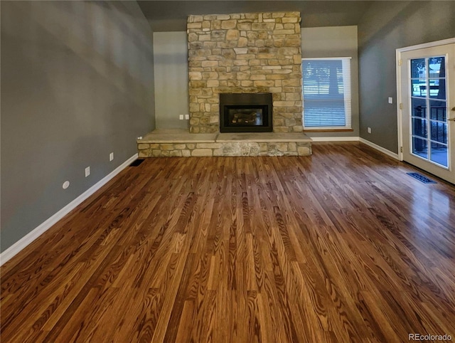 unfurnished living room with dark wood-type flooring and a fireplace