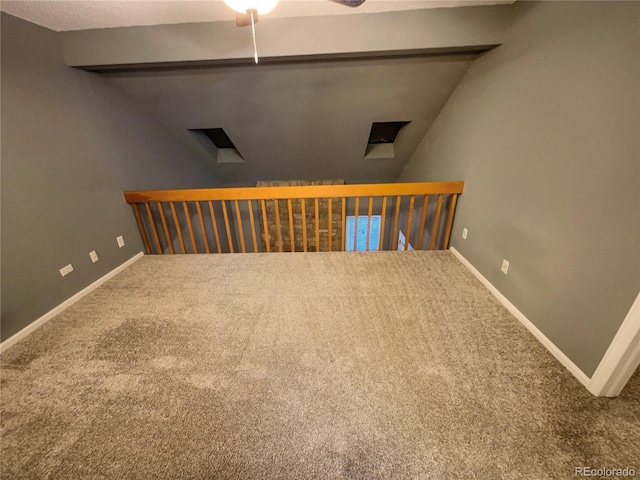 carpeted spare room featuring vaulted ceiling and ceiling fan