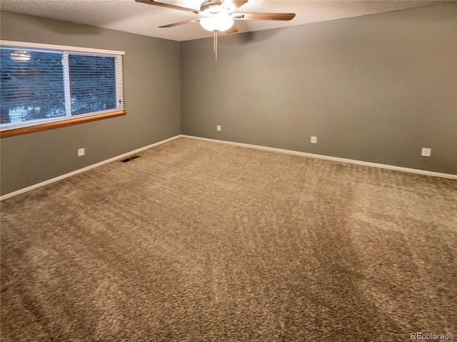 carpeted empty room featuring ceiling fan and a textured ceiling