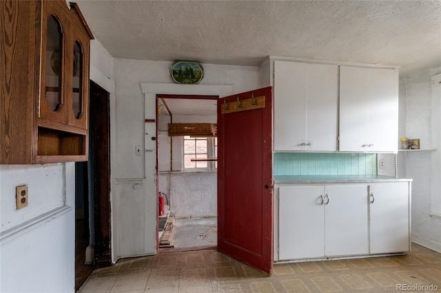 kitchen featuring backsplash and white cabinetry