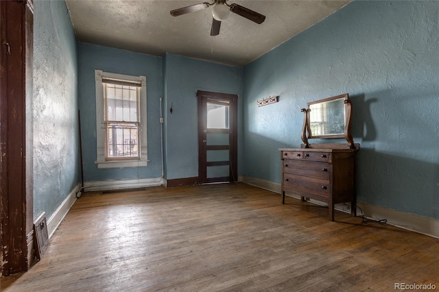 entrance foyer featuring ceiling fan, wood-type flooring, and a textured ceiling