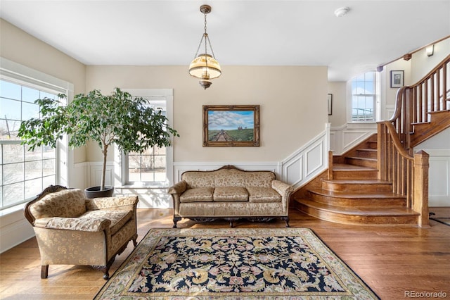 7996 Bradburn Blvd, Westminster, CO 80030 - living area featuring wood finished floors, a decorative wall, stairway, and a wainscoted wall